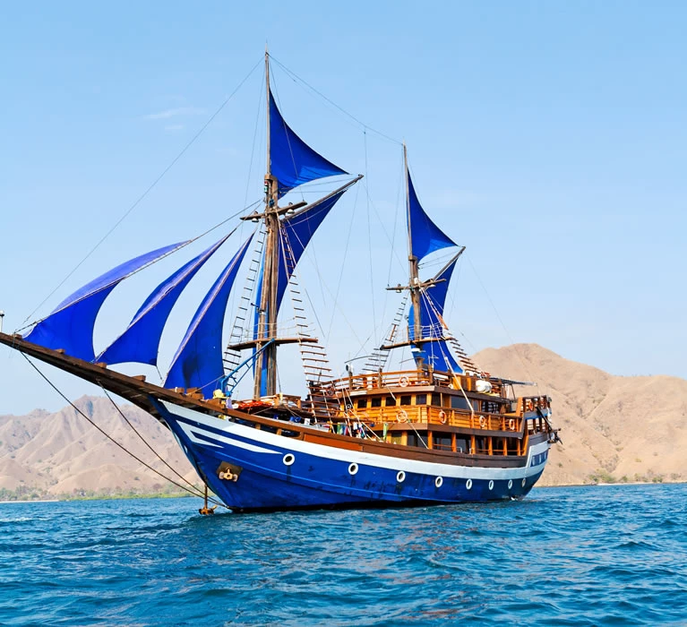 sailing-cruise-vintage-wooden-ship-with-blue-sails-near-komodo-island-indonesia-copyrigth-shutterstock_115653610.jpg